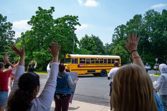 Faculty from a middle school in Fairfax County, Virginia, wave goodbye to the final departing bus on the last day of school in on June 11.