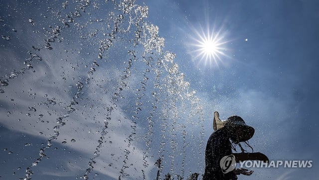 Children play in a fountain in Daegu, about 278 kilometers southeast of Seoul, on July 24, 2025, to cool off. (Yonhap)