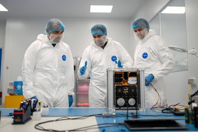 El conseller Albert Dalmau, el consejero delegado de Open Cosmos, Rafael Jordá, y el director de i2CAT, Sergi Figuerola, frente al satélite