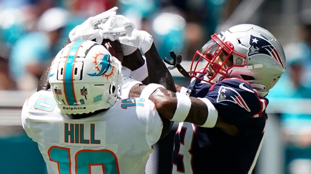Dolphins wide receiver Tyreek Hill grabs a pass over Patriots defensive back Jack Jones (13 ) on Sept. 11 in Miami Gardens.