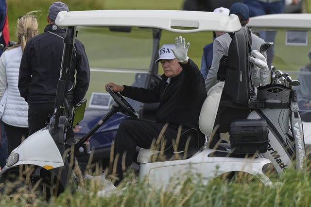 President Donald Trump waves to reporters as he sits in his golf cart at the Trump Turnberry golf course in Turnberry, Scotland, Saturday, July 26, 2025.(AP Photo/Alastair Grant)