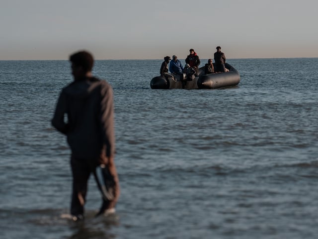 GRAVELINES, FRANCE - JUNE 17: A man wades into the water as a dinghy waits to load migrants to sail into the English Channel on June 17, 2025 in Gravelines, France. A record number of migrants have made the illegal crossing from France to the UK via small boats so far this year. Figures surpassed the 16,000 mark last week, which is 42% more than the same point last year. The UK government has vowed to crackdown on people smugglers and illegal migration, with Chancellor Rachel Reeves announcing as part of the government's spending review that the Border Security Command would be funded up to £280m more per year by the end of the review period in 2028-29. (Photo by Carl Court/Getty Images)