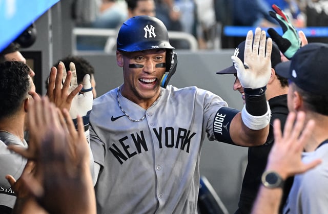 Jul 23, 2025; Toronto, Ontario, CAN;  New York Yankees designated hitter Aaron Judge (99) celebrates with team mates in the dugout after hitting a two run home run against the Toronto Blue Jays in the sixth inning at Rogers Centre. Mandatory Credit: Dan Hamilton-Imagn Images/File Photo