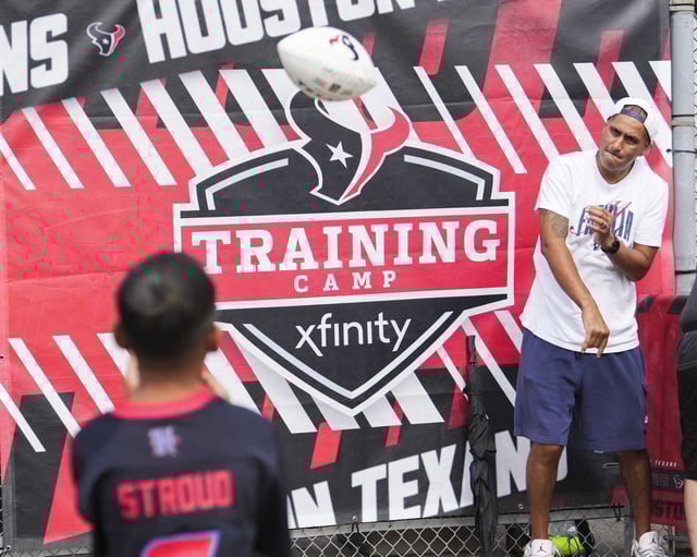 Alex Perez, right, throws a pass to his son, Alex Paul Perez, during an NFL training camp practice at Houston Methodist Training Center in Houston, Saturday, July 26, 2025.