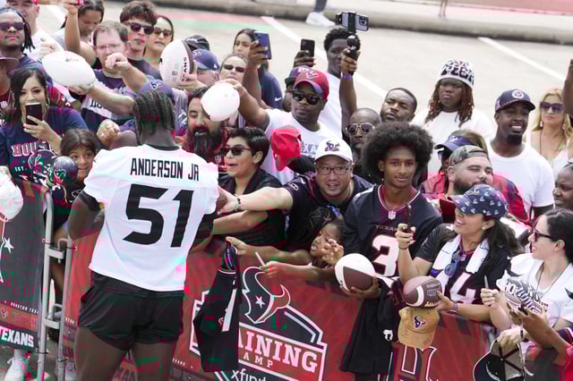 Houston Texans defensive end Will Anderson Jr. (51) signs autographs for fans after an NFL training camp practice at Houston Methodist Training Center in Houston, Saturday, July 26, 2025.