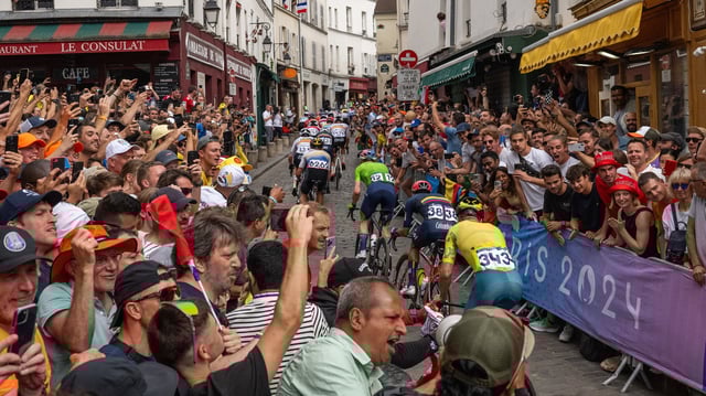 Des cyclistes traversent la côte de la butte Montmartre sous les acclamations des supporters lors de la course sur route masculine, le 3 août, lors des Jeux olympiques 2024.