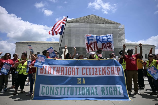 People hold a banner as they protest outside the Supreme Court over Donald Trump’s move to end birthright citizenship, on May 15, 2025.