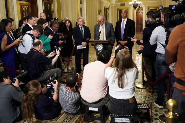 U.S. Senate Minority Leader Sen. Chuck Schumer (D-NY) (C) speaks as Senate Minority Whip Sen. Richard Durbin (D-IL) (L) and Sen. Cory Booker (D-NJ) (R) listen during a news briefing after the weekly Senate Democratic policy luncheon at the U.S. Capitol on July 22, 2025 in Washington, DC.
