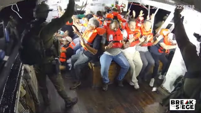 A still from a livestream shows armored personnel intercepting the Handala, with those aboard surrendering immediately.
