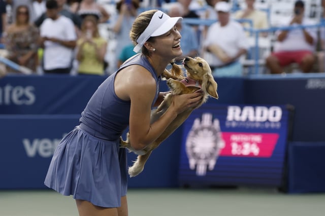 Jul 26, 2025; Washington, D.C., USA; Anna Kalinskaya plays with her dog Bella on the court after her match against Emma Raducanu (GBR)(not pictured) in a women's singles semi-final on day six of the Mubadala Citi DC Open at Rock Creek Park Tennis Center. Mandatory Credit: Geoff Burke-Imagn Images