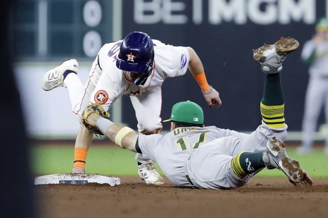 Houston AstrosÕ Zack Short, left, is tagged out at second base by Athletics second baseman Luis Urias (17) during the fifth inning of a baseball game Saturday, July 26, 2025, in Houston.