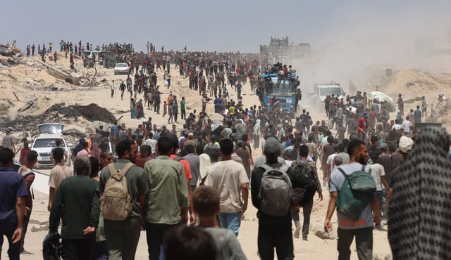 People make their way along al-Rashid street in western Jabalia on July 22, 2025, towards trucks carrying humanitarian aid after they entered the northern Gaza Strip through the Israeli-controlled Zikim border crossing. The head of Gaza’s largest hospital on July 22, said 21 children have died due to malnutrition and starvation in the Palestinian territory in the past three days, while Israel pressed a devastating assault. (Photo by Omar AL-QATTAA / AFP) (Photo by OMAR AL-QATTAA/AFP via Getty Images)