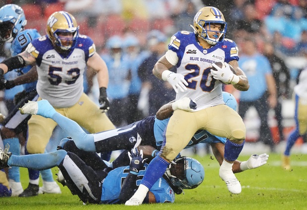 Winnipeg Blue Bombers running back Brady Oliveira (20) tries to break through the Toronto Argonauts defence during first half CFL football action in Toronto on Saturday. Oliveira ran the ball 13 times for 82 yards with one lost fumble. He also caught two passes for 38 yards.