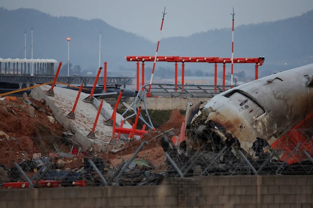 The wreckage of the Jeju Air aircraft that went off the runway and crashed at Muan International Airport lies near a concrete structure it crashed into, in Muan, South Korea, December 30, 2024. REUTERS/Kim Hong-Ji/File Photo