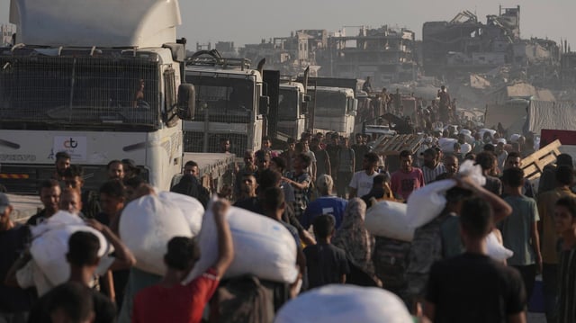 Palästinenser tragen Mehlsäcke, die von einem humanitären Hilfskonvoi abgeladen wurden, der Gaza-Stadt aus dem nördlichen Gazastreifen erreicht hat