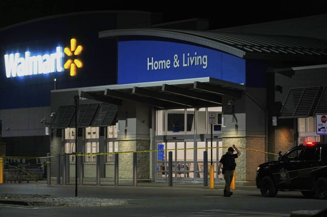 Law enforcement officers cross caution tape outside a Walmart where 11 people were stabbed in a violent attack in Traverse City, Michigan, on Saturday.