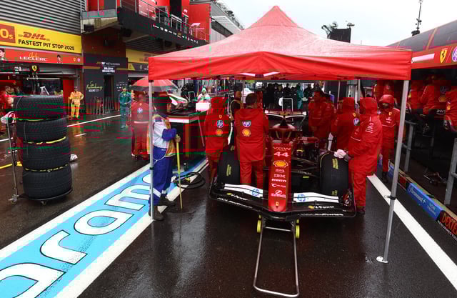 Formula One F1 - Belgian Grand Prix - Circuit de Spa-Francorchamps, Stavelot, Belgium - July 27, 2025 Ferrari mechanics with Ferrari's Lewis Hamilton car in the pit lane after the start of the race was delayed due to weather REUTERS/Yves Herman/Pool