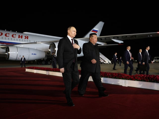 In this pool photograph distributed by the Russian state agency Sputnik, North Korea's leader Kim Jong Un (R) walks with Russian President Vladimir Putin during a welcoming ceremony upon Putin's arrival at Pyongyang Airport, early on June 19, 2024. Russian President Vladimir Putin landed in North Korea early on June 19, the Kremlin said, kicking off a visit set to boost defence ties between the two nuclear-armed countries as Moscow pursues its war in Ukraine. (Photo by Gavriil GRIGOROV / POOL / AFP) (Photo by GAVRIIL GRIGOROV/POOL/AFP via Getty Images)