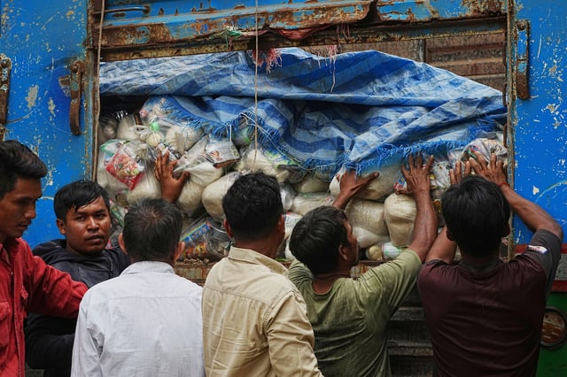 Local villagers help unloading supplies donated by a charity for refugees from a truck, as they take refuge in Wat Phnom Kamboar, Oddar Meanchey province, Cambodia, Sunday, July 27, 2025, amid the fighting between Thailand and Cambodia.