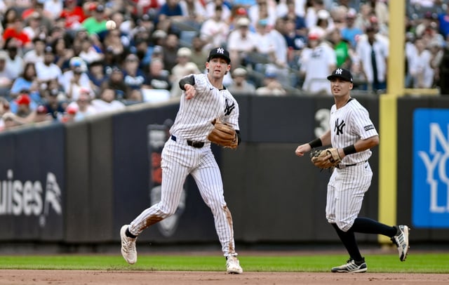 Jul 27, 2025; Bronx, New York, USA; New York Yankees third baseman Ryan McMahon (19) throws to first base for an out during the fifth inning against the Philadelphia Phillies at Yankee Stadium. Mandatory Credit: John Jones-Imagn Images