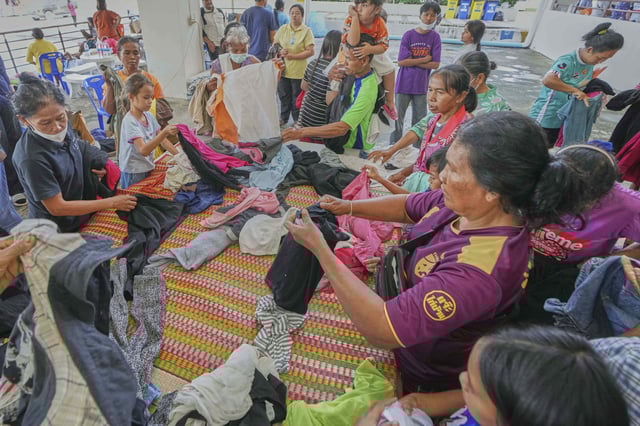 Thai residents select donated clothes as they fled homes following the clashes between Thai and Cambodian soldiers, at an evacuation center in Surin province, Thailand, Monday, July 28, 2025. (AP Photo/Sakchai Lalit)