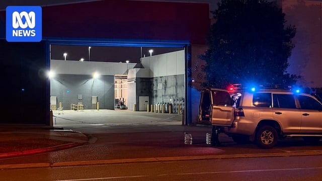 Police vehicles parked outside a shopping centre loading dock.