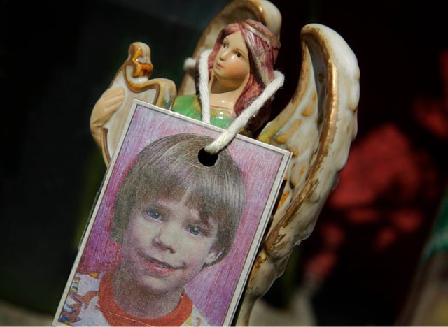 FILE- In this May 28, 2012 file photo, an image of Etan Patz hangs on an angel figurine, part of a makeshift memorial in the SoHo neighborhood of New York where the boy lived. Pedro Hernandez, a man unsuspected for decades in one of the nation&#39;s most haunting missing-child cases, has been convicted nearly 38 years after 6-year-old Patz disappeared in New York City. (AP Photo/Mark Lennihan, File)