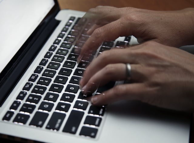 FILE - A person working on a laptop in North Andover, Mass., June 19, 2017. (AP Photo/Elise Amendola, File)