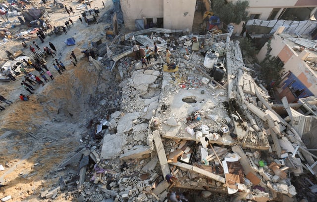 Palestinians gather at the site of an overnight Israeli air strike on a house, in Khan Younis in the southern Gaza Strip, July 28, 2025. REUTERS/Ramadan Abed/File Photo