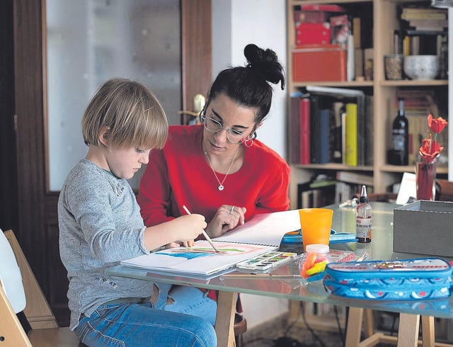 Una madre ayuda a su hijo a realizar las tareas escolares.