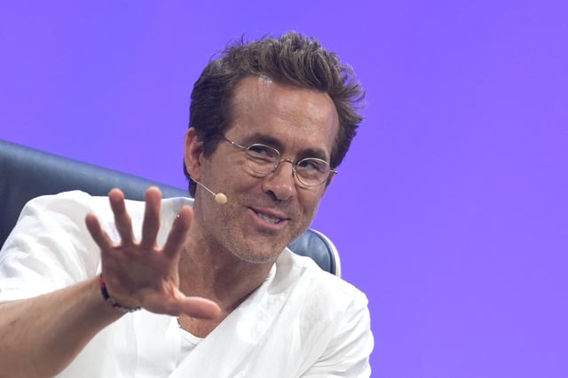 Ryan Reynolds, actor, entrepreneur and co-owner of Welsh soccer club Wrexham AFC, gestures on stage during the OMR digital and marketing fair in the exhibition halls.