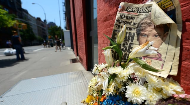 People walk past a street shrine to six-year-old Etan Patz, who went missing in 1979, set in front of the building where suspect Pedro Hernandez confessed to having strangled the boy in New York on May 29, 2012. (EMMANUEL DUNAND/AFP/GettyImages/Courtesy)