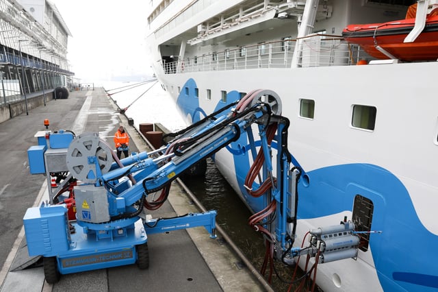 Ein Servicetechniker justiert den mobilen Kran der Landstromanlage am Cruise Center Altona mit einer Stromverbindung zu dem Kreuzfahrtschiff „Aidasol“ (Archivfoto).