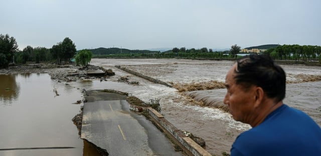 Une route endommagée est visible dans une zone inondée après de fortes pluies dans le village de Taishitun, dans le district de Miyun, à la périphérie de Pékin, le 28 juillet 2025