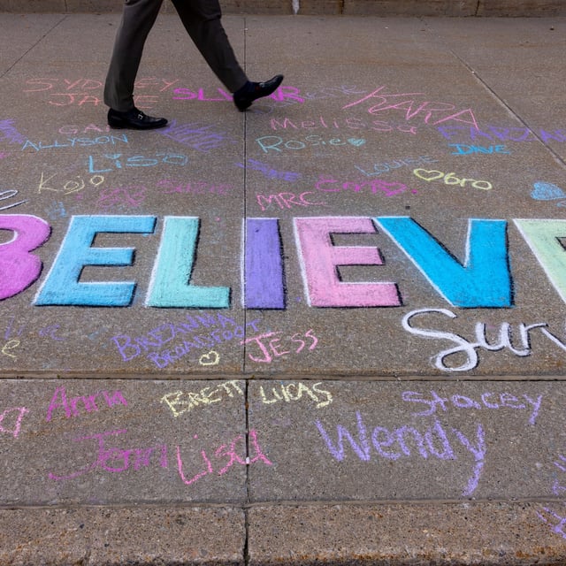 A person walks the sidewalk painted by supporters of the complainant, E.M., whose identity is protected under a standard publication ban, as a judge announced the verdict in the trial of five members of Canada’s 2018 gold medal–winning world junior hockey team, charged with sexually assaulting a woman in a hotel room, at the Superior Court of Justice in London, Ontario, Canada, July 24, 2025. REUTERS/Carlos Osorio