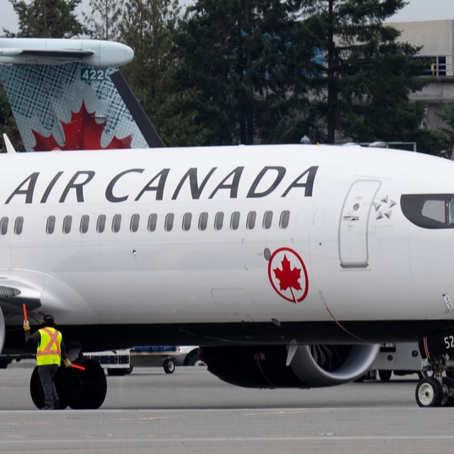 An Air Canada jet is manoeuvred on the tarmac at the airport, Wednesday, Nov.15, 2023 in Vancouver.  THE CANADIAN PRESS/Adrian Wyld