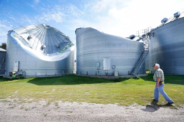 FILE - Rod Pierce looks at grain drying bins on his farm that were damaged in the derecho earlier this month, Aug. 20, 2020, near Woodward, Iowa. (AP Photo/Charlie Neibergall, file)