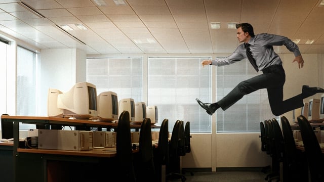 Photo of someone running though the air to reach a computer.