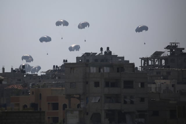 A military transport aircraft drops humanitarian aid over Al-Zawayda, in the central Gaza Strip, on July 28, 2025.