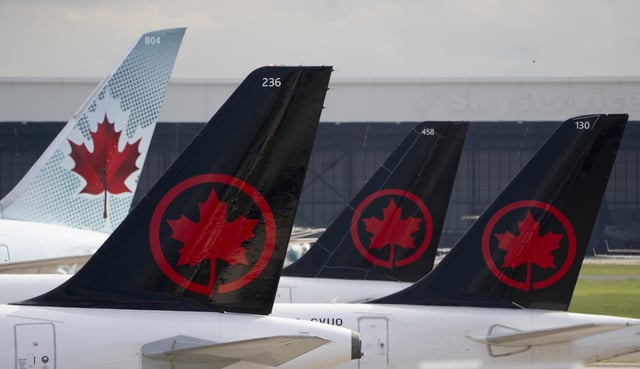 Air Canada logos are seen on the tails of planes at the airport in Montreal on June 26, 2023. THE CANADIAN PRESS/Adrian Wyld
