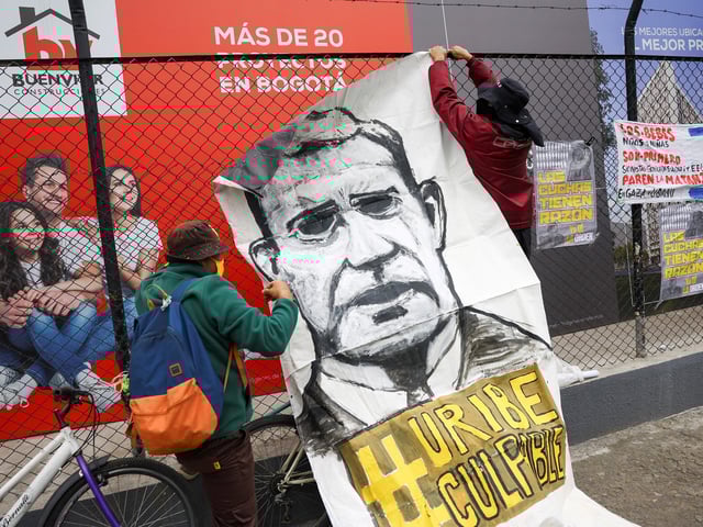 People hang a banner reading "Uribe guilty", as they protest against former Colombian President Alvaro Uribe outside the Paloquemao court complex while waiting for the ruling in a criminal case against him, in Bogota, Colombia, July 28, 2025. REUTERS/Luisa Gonzalez