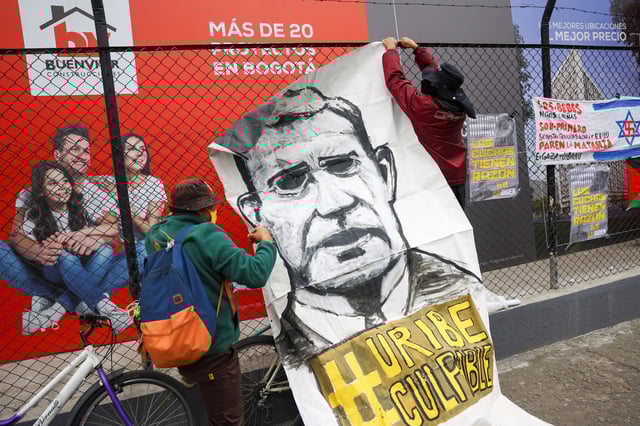 Un manifestant tient une banderole sur laquelle est écrit «Uribe coupable», alors qu’il proteste contre l’ancien président colombien devant le tribunal de Paloquemao, à Bogota, en Colombie, le 28 juillet 2025.