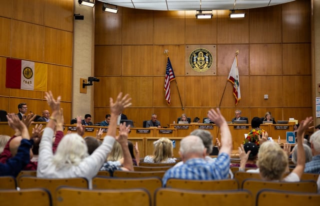 People show they agree with a speaker as they address the San Diego City Council on a plan to start charging for parking in Balboa Park on Monday, July 28, 2025.   (Ana Ramirez / The San Diego Union-Tribune)