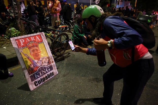 A man records a poster depicting former Colombian President Alvaro Uribe, as people gather in celebration, after a judge found Uribe guilty of abuse of process and bribery of a public official, in Bogota, Colombia July 28, 2025. REUTERS/Luisa Gonzalez