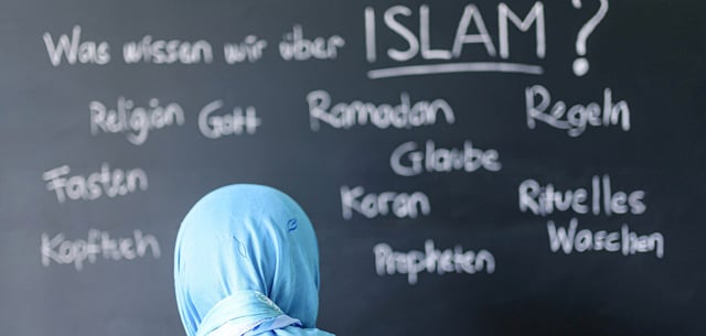 Eine muslimische Schülerin vor einer Tafel mit Begriffen aus dem Islam im Islamunterricht