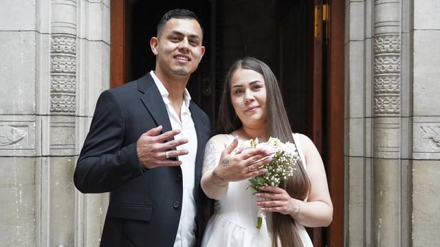Newlyweds Magdalena Kujawińska, right, from Poland and Heinner Valenzuela from Colombia pose for photos at the Copenhagen City Hall in Copenhagen, Denmark. Wednesday 9 July 2025. (AP Photo/James Brooks)
