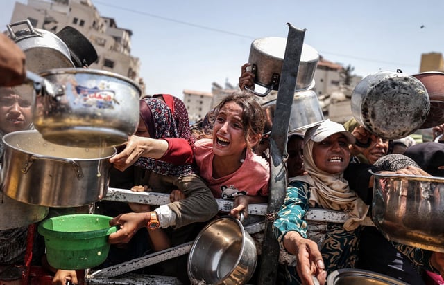 A charity distributes meals to Palestinians facing food shortages  in Gaza City on July 28, 2025. 