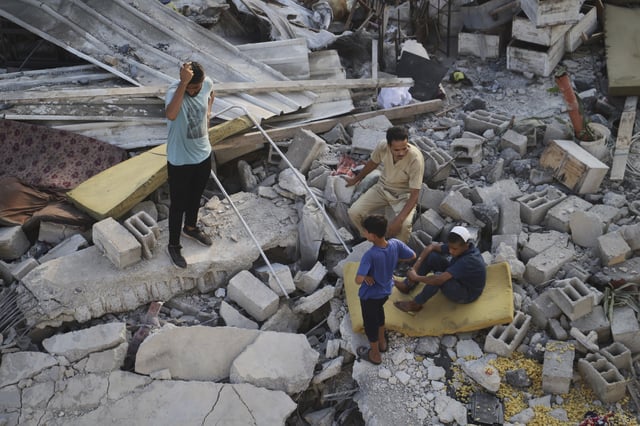 Palestinians inspect the site struck by an Israeli bombardment in Muwasi, Khan Younis, Gaza Strip, Monday, July 28, 2025. (AP Photo/Mariam Dagga)