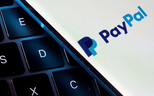 A smartphone with the PayPal logo is placed on a laptop in this illustration taken on July 14, 2021. REUTERS/Dado Ruvic/Illustration/File Photo