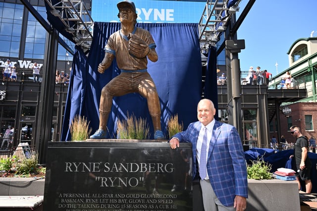 CHICAGO, IL - JUNE 23: Former Chicago Cubs player and Hall of Famer Ryne Sandberg poses for pictures in front of his statue before a game against the New York Mets at Wrigley Field on June 23, 2024 in Chicago, Illinois.